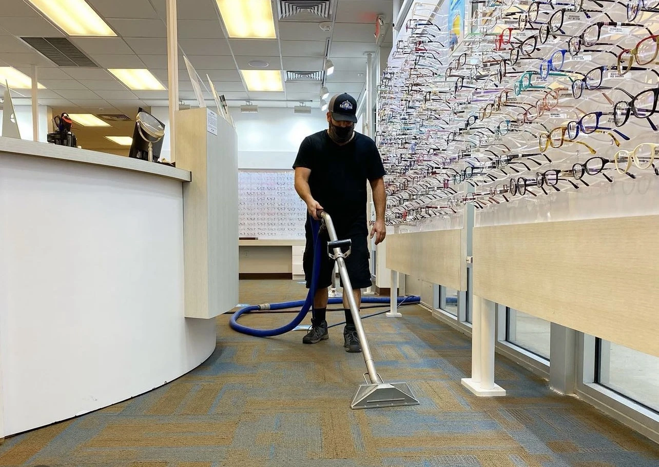 Technician steam cleaning the carpet of a retail store