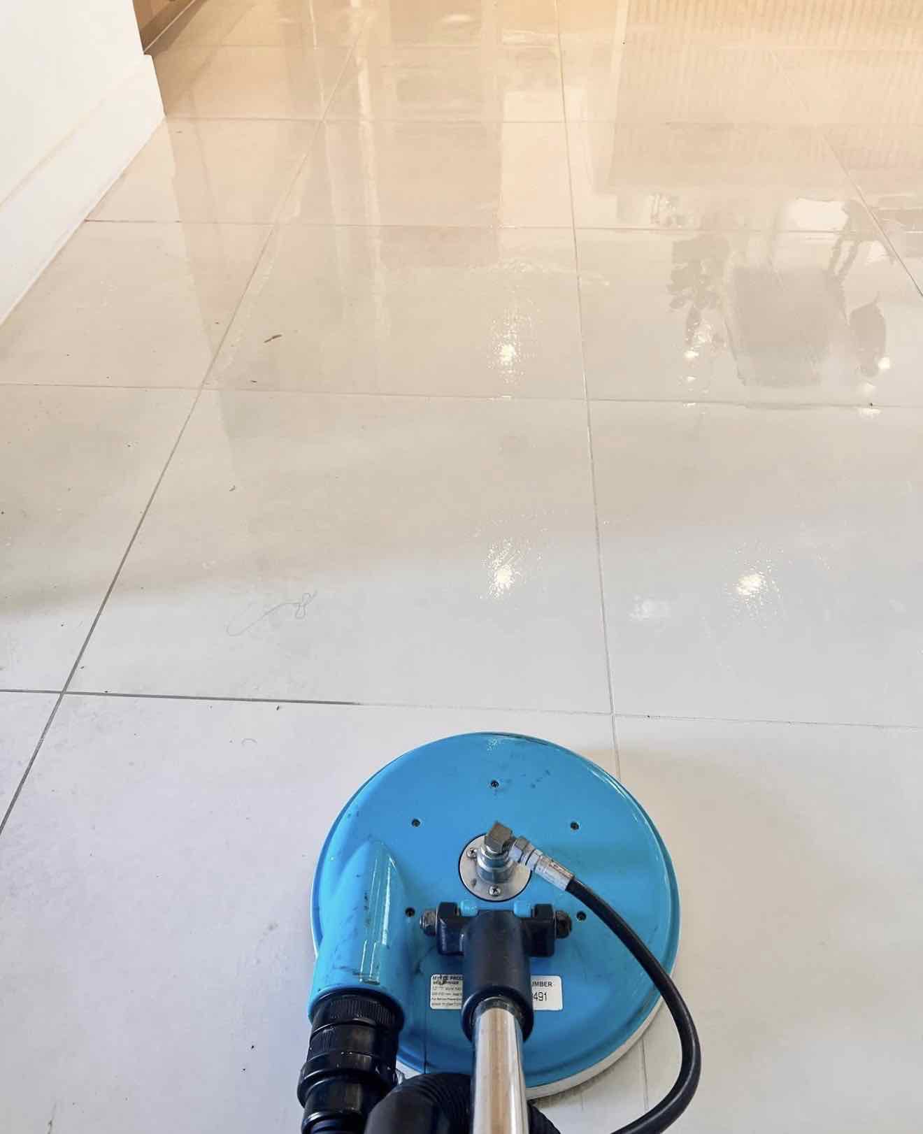 Spinner tool steam-cleaning a glossy tile floor