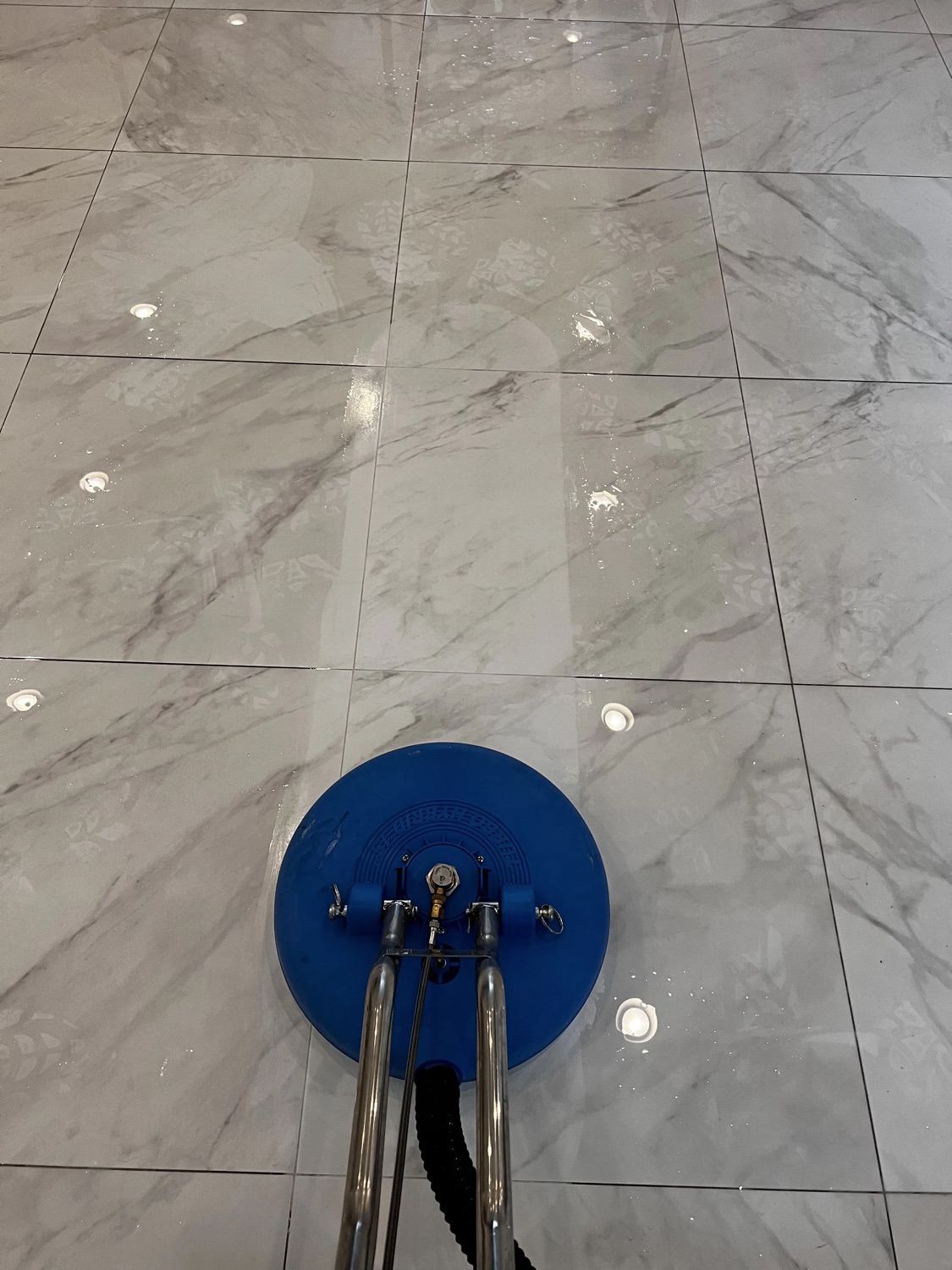 Marble-look tile floor mid steam cleaning
